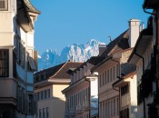 Imposant blicken die Bergsilhouetten und verschneiten Berggipfel hinter den Häusern der Bozner Altstadt hervor
