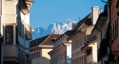 Imposant blicken die Bergsilhouetten und verschneiten Berggipfel hinter den Häusern der Bozner Altstadt hervor